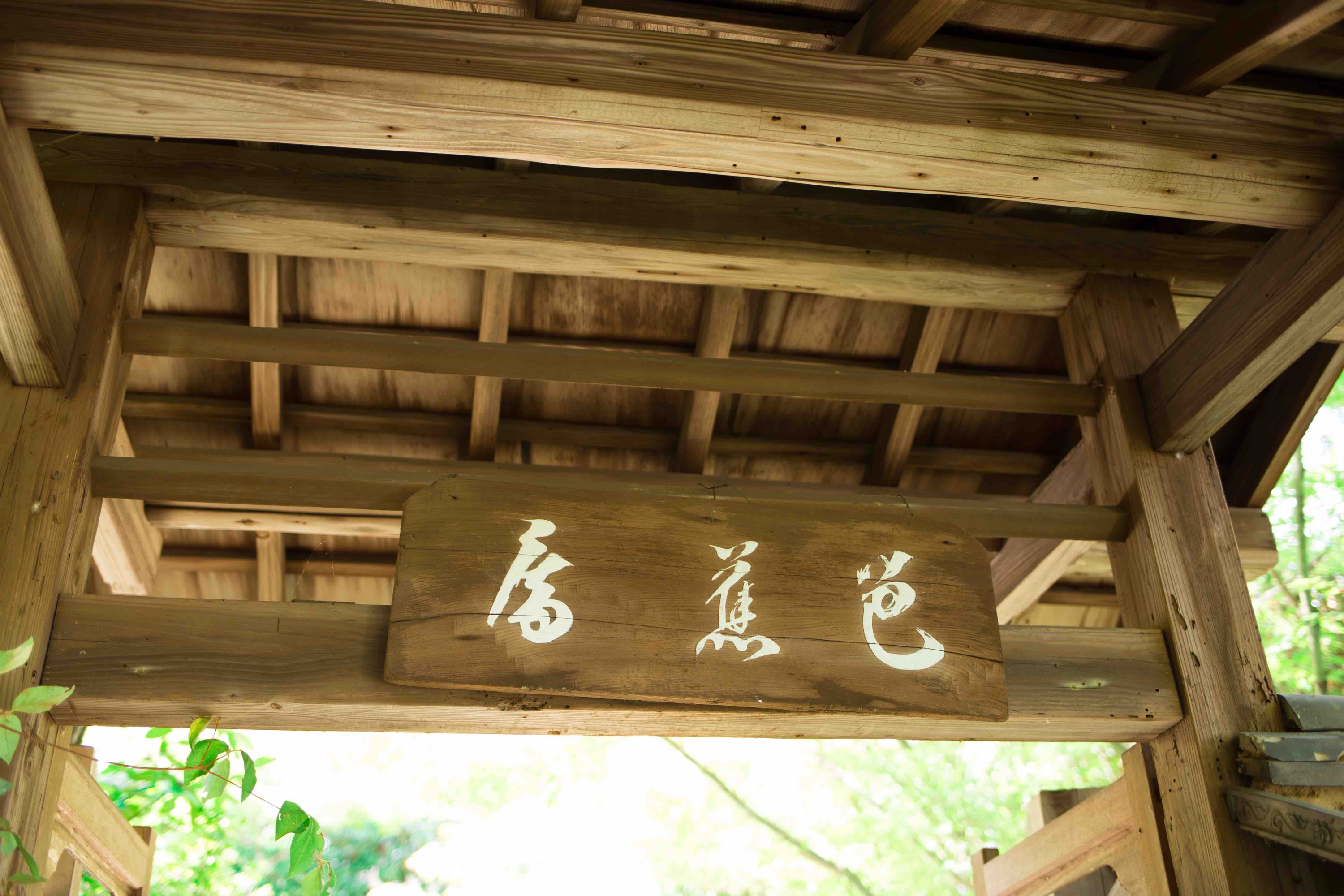 新緑に包まれる金福寺の「芭蕉庵」と書かれた門